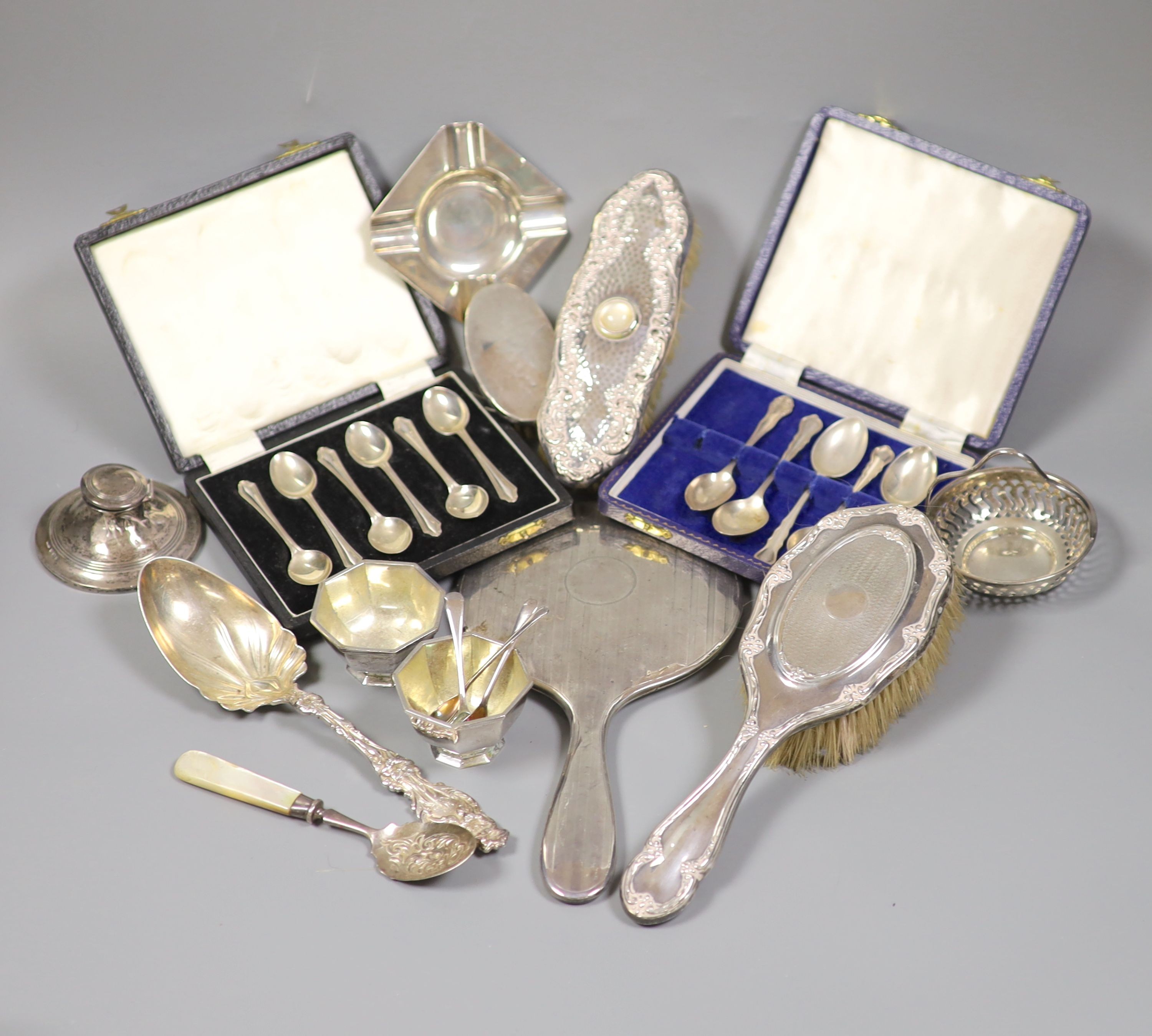 A collection of small silver including condiments, mirror and brushes, astray, cased items and a pair of sterling servers.